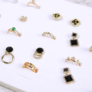 Selection of luxury gold rings and earrings with green stones in white foam display tray