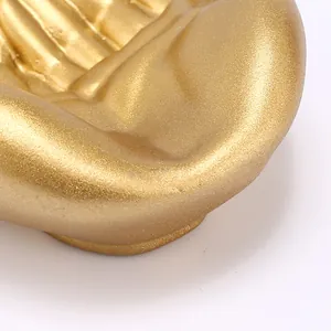 Macro detail of golden resin hand-shaped jewelry holder with matte glitter finish