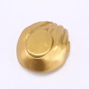 Macro shot of matte gold heart palm resin jewelry holder showing hand carved texture