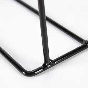 Detail showing the welded base and glossy black iron finish of the jewelry display stand