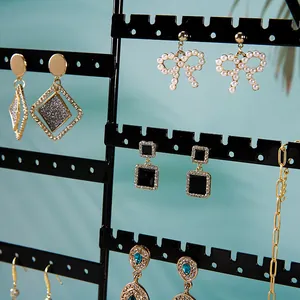 Expositor de joyas hexagonal con base de pino y varios pendientes elegantes