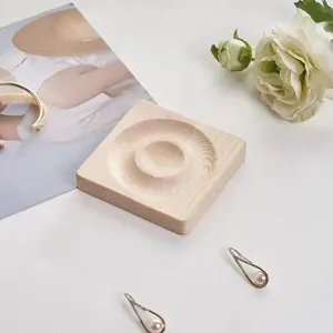 Makroaufnahme der quadratischen Schmuckschale aus Holz mit runder Vertiefung für Ringe