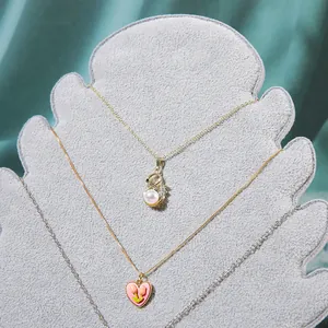 Dettaglio delle collane con cigno e cuore tulipano su supporti in velluto grigio