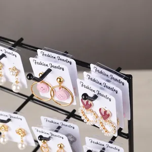 Λεπτομέρεια μαύρης βάσης κοσμημάτων με σκουλαρίκια από πέρλες σε κάρτες προβολής