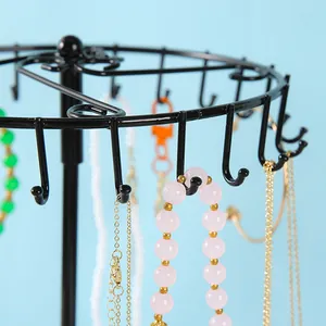 Gros plan détaillé d'un présentoir à bijoux rotatif noir avec crochets en J