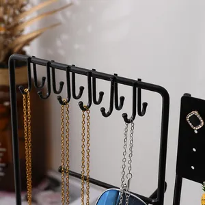 Détail du support à bijoux en métal noir avec crochets en U et colliers suspendus