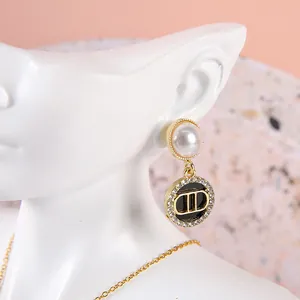 Elegant gold resin bust mannequin displaying pearl and rhinestone pendant earrings for jewelry