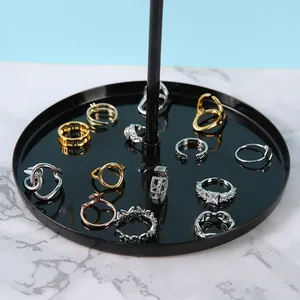 Présentoir à bijoux rotatif noir avec diverses bagues minimalistes dorées et argentées