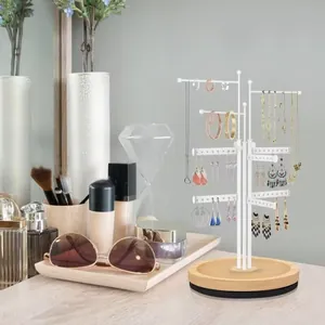 Multi-tier jewelry stand with white metal frame and wood base on a vanity table