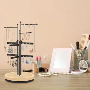 Vertical jewelry organizer with black metal frame and round wooden base for earrings