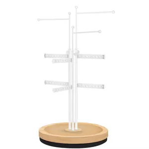 Close-up of a white metal jewelry stand with multi-layer earring hooks and wood base