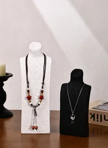 Close-up of ethnic beaded necklace and floral pendant on portrait neck display stand