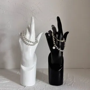 Minimalistische hand sieradenhouder van hars in zwart en wit voor kettingen en armbanden
