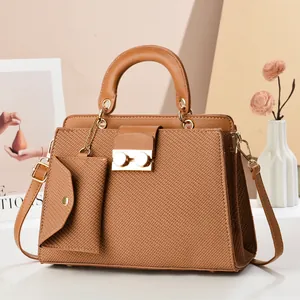 Conjunto de bolso marrón con textura de lagarto, asa superior y bandolera