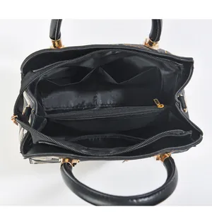 Internal view of the large capacity handbag featuring multiple compartments and gold hardware