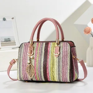 Rainbow striped woven tote bag with pink leather handles and golden leaf charm