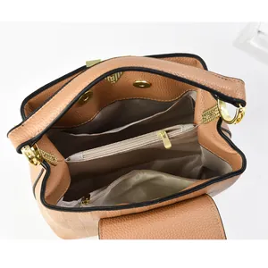 Vue intérieure du sac en cuir marron clair montrant les compartiments et détails dorés