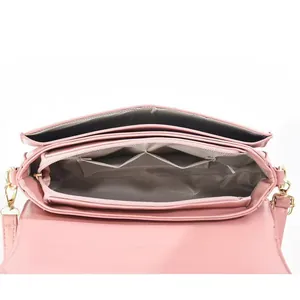 Innenansicht der rosa Schultertasche mit mehreren Fächern und goldenen Metallelementen
