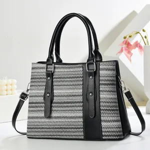 Detail of woven handbag showing silver hardware and detachable leather shoulder strap