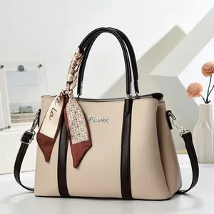 Fashionable beige and brown patchwork leather tote bag with decorative silk scarf handle