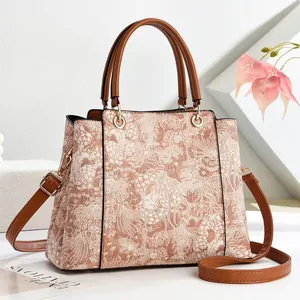 Elegant floral jacquard tote bag with brown leather trim and golden hardware detailing