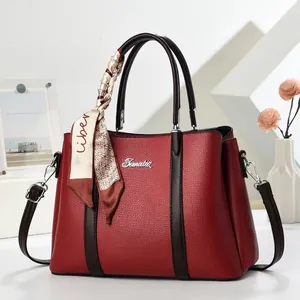 Elegant red lychee grain handbag with contrast brown handles and decorative scarf