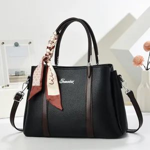 Elegant black lychee leather handbag with brown stripes and decorative silk scarf wrap