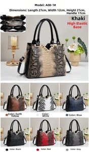 Detail view of glossy faux leather tote bag with snakeskin texture and gold V-shaped hardware