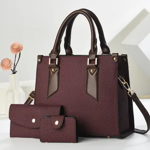 Detailed set of three burgundy woven handbags with leather trim and gold hardware accents