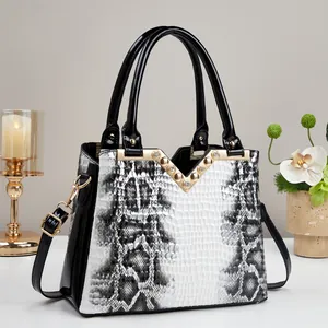 Chic black and white snakeskin pattern handbag with glossy patent leather and gold accents