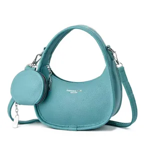 Sac à main croissant en cuir cyan avec pochette ronde assortie et texture grainée