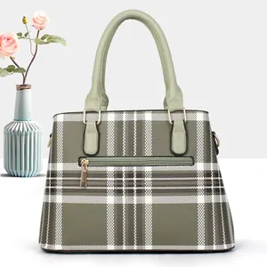 Green and white plaid trapezoid tote bag with gold metal rings and front zipper pocket