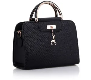 Detail of black faux leather handbag with diagonal texture, metal ring handle and deer charm