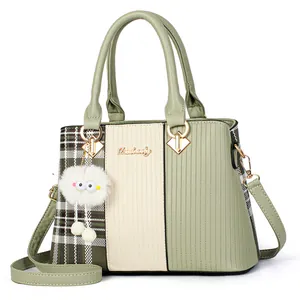 Green and white patchwork tote bag with embossed textures and a cute plush charm
