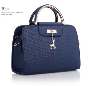 Detail of blue quilted handbag with golden deer charm and lychee texture finish