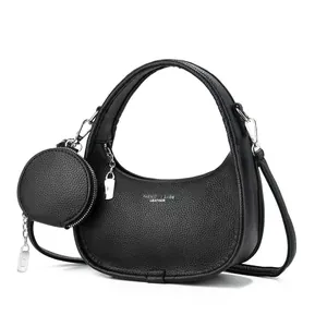 Sac croissant noir en cuir grainé avec une petite pochette ronde amovible attachée