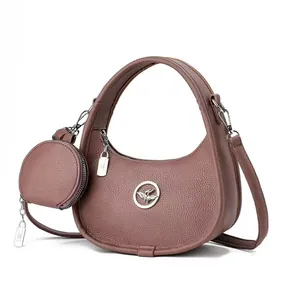 Sac à main chic en forme de croissant avec texture cuir et emblème d'oiseau en métal