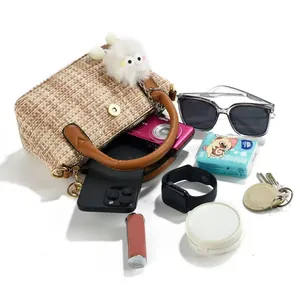 Top view of woven khaki handbag showing interior space for phone, camera and sunglasses