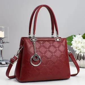 Borsa bordeaux in pelle goffrata con finiture argentate in un set fotografico curato
