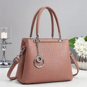 Elegant dusty pink crossbody handbag with geometric embossing and silver hardware accents