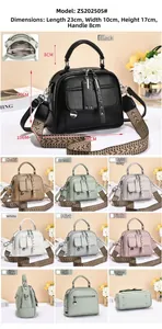 Detail view of compact square crossbody bag showing wide strap and multi-pocket layout
