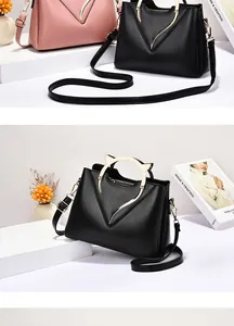 Detail of trendy cat-ear metal handles and V-shaped hardware on leather handbags