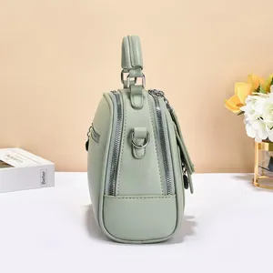 Detail view of the light green crossbody bag with pebbled leather and silver D-rings