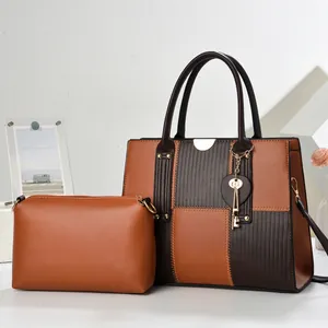 Détail du sac fourre-tout bicolore avec breloque cœur et pochette intérieure marron