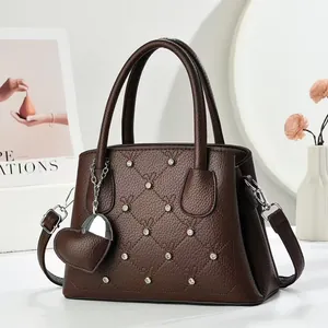 Deep brown quilted leather handbag with rhinestone accents and heart charm detail