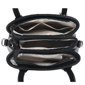 Internal view of the black leather bag showing three compartments and zipper divider