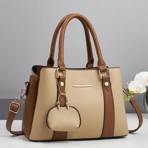 Detail view of contrast color handbag with lychee pattern leather and gold hardware