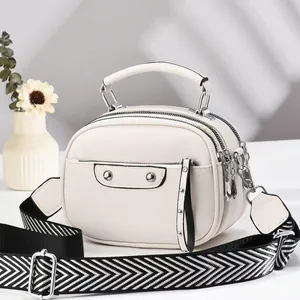 Detail of cream white PU leather crossbody bag with geometric pattern wide strap