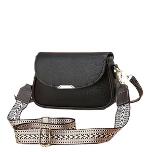 Sac bandoulière noir à motif litchi avec une large sangle géométrique bohème
