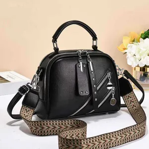 Black pebbled leather handbag with silver zippers and ethnic style woven strap